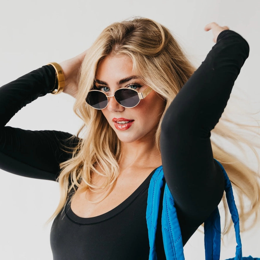 Modelo usando lentes de sol ovales dorados