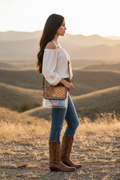 Modelo de perfil luciendo la bolsa transparente con solapa de cuero tooled western