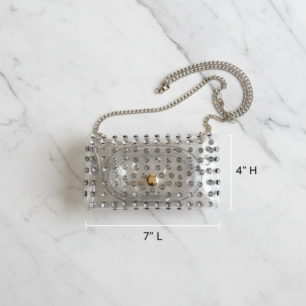 Clear rhinestone bag flat lay with measurements 7 inches long by 4 inches tall on white marble surface